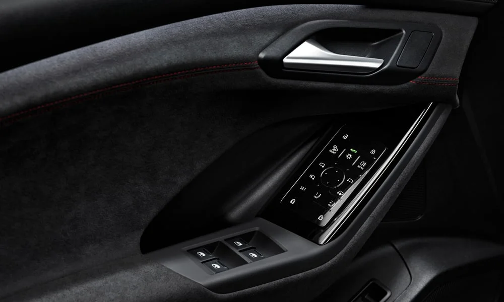 Фото Audi SQ6 e-tron (2024) — дверная карта. Внутренняя панель двери: сочетание материалов и компоновка управления в тёмной гамме. Решётка динамика в двери — часть штатной акустики Audi SQ6 e-tron (2024) — дверная карта