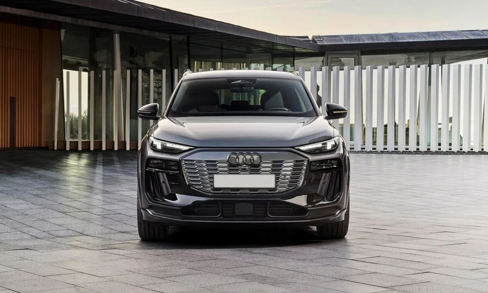 Фото Audi SQ6 e-tron (2024) — вид спереди, фото 4. Кузов в сером цвете: рисунок оптики и решётки задаёт узнаваемое «лицо» модели. Дневные ходовые огни включаются автоматически с запуском Audi SQ6 e-tron (2024) — вид спереди, фото 4