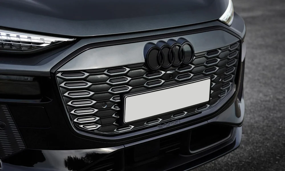 Фото Audi SQ6 e-tron (2024) — решётка радиатора. Рисунок решётки: сетка, ламели или глухая панель у электроверсий. За решёткой у многих комплектаций стоит радар адаптивного круиз-контроля Audi SQ6 e-tron (2024) — решётка радиатора