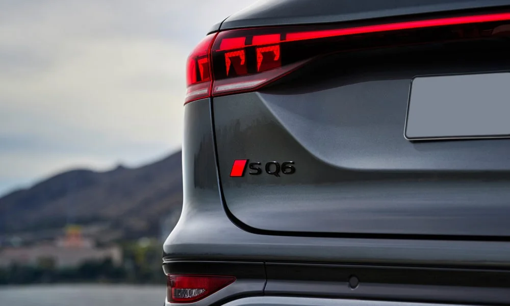 Фото Audi SQ6 e-tron (2024) — вид сзади, фото 7. Серый кузов сзади — фонари и бампер определяют ночной образ модели. Насадки выхлопа или их имитация внизу бампера различают версии Audi SQ6 e-tron (2024) — вид сзади, фото 7