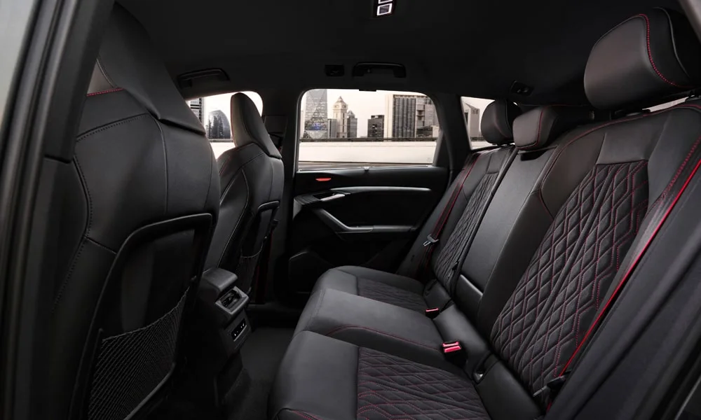 Фото Audi SQ6 e-tron (2024) — задние сиденья. Посадка второго ряда: подголовники и подлокотник. Крепления ISOFIX для детских кресел — в основании спинки Audi SQ6 e-tron (2024) — задние сиденья