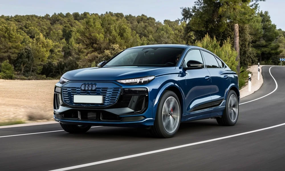 Фото Audi SQ6 Sportback e-tron (2024) — вид спереди, фото 7. Синий кузов, строгая симметрия оптики — базовый ракурс знакомства с дизайном. Дневные ходовые огни включаются автоматически с запуском Audi SQ6 Sportback e-tron (2024) — вид спереди, фото 7