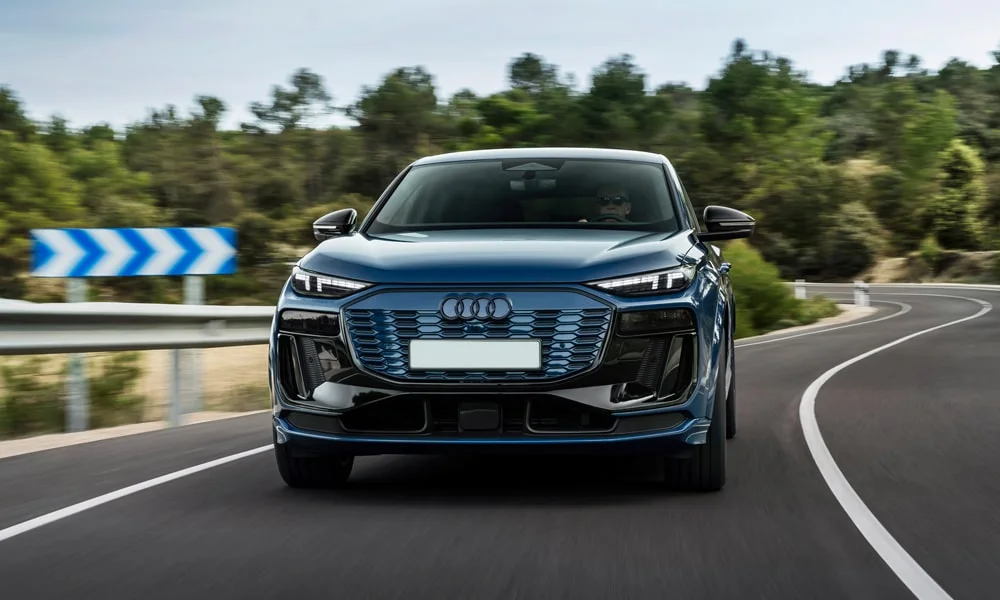 Фото Audi SQ6 Sportback e-tron (2024) — вид спереди, фото 8. Анфас: пропорции капота, посадка кузова и графика ходовых огней. Дневные ходовые огни включаются автоматически с запуском Audi SQ6 Sportback e-tron (2024) — вид спереди, фото 8