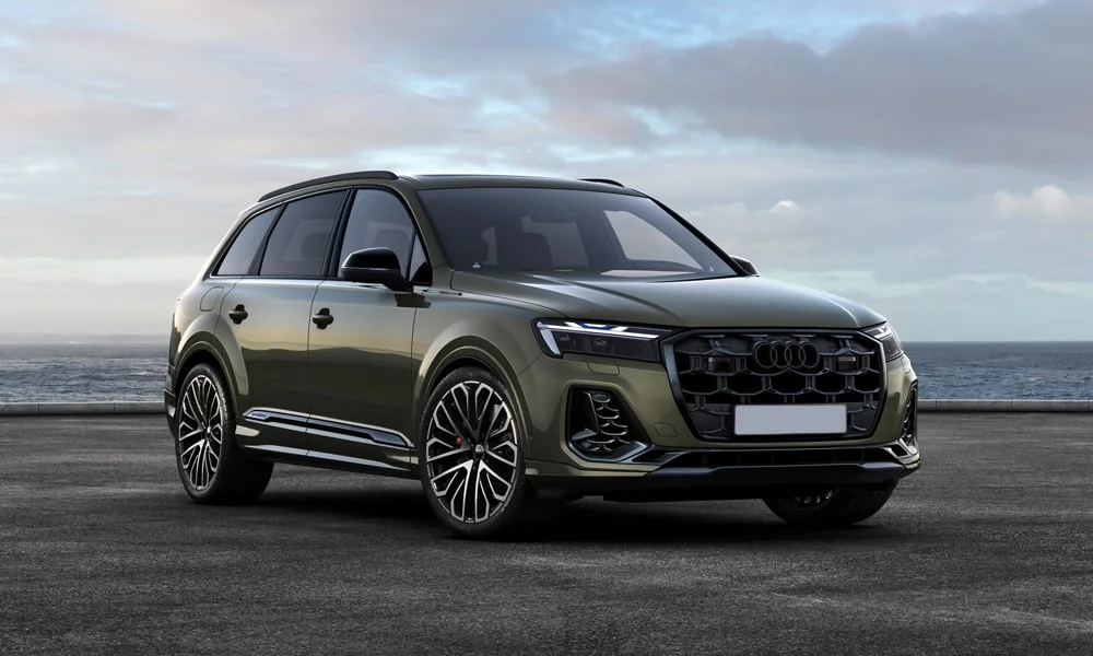 Фото Audi SQ7 (2024) — вид спереди, фото 11. Кузов в зелёном цвете: рисунок оптики и решётки задаёт узнаваемое «лицо» модели. Рисунок ходовых огней — подпись модели, по нему её узнают в потоке Audi SQ7 (2024) — вид спереди, фото 11