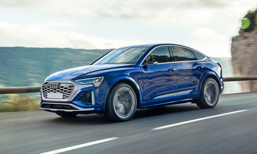Фото Audi SQ8 Sportback e-tron (2024) — вид спереди, фото 10. Синий кузов, строгая симметрия оптики — базовый ракурс знакомства с дизайном Audi SQ8 Sportback e-tron (2024) — вид спереди, фото 10