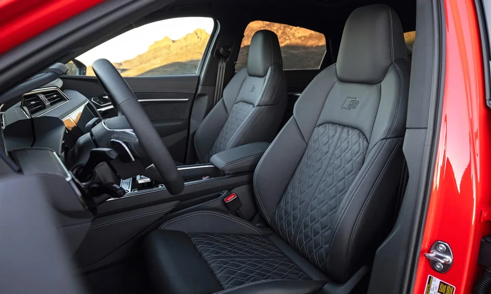 Фото Audi SQ8 Sportback e-tron (2024) — передние сиденья. Передние кресла в перфорированной коже. Выраженная боковая поддержка держит в поворотах Audi SQ8 Sportback e-tron (2024) — передние сиденья