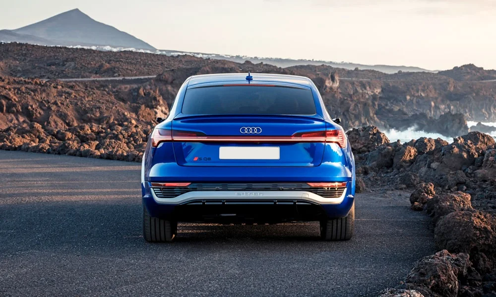 Фото Audi SQ8 Sportback e-tron (2024) — вид сзади, фото 7. Синий кузов сзади — фонари и бампер определяют ночной образ модели Audi SQ8 Sportback e-tron (2024) — вид сзади, фото 7