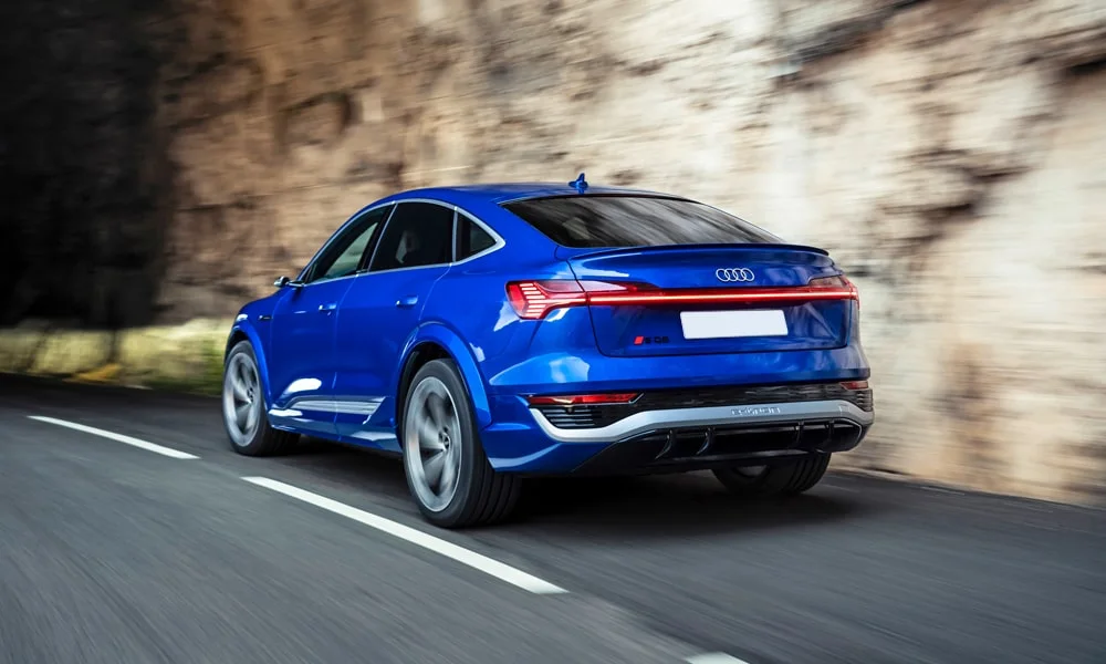 Фото Audi SQ8 Sportback e-tron (2024) — вид сзади, фото 8. Синий кузов сзади — фонари и бампер определяют ночной образ модели. Насадки выхлопа или их имитация внизу бампера различают версии Audi SQ8 Sportback e-tron (2024) — вид сзади, фото 8