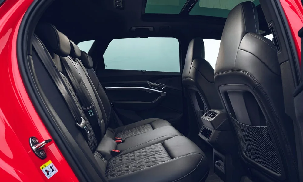 Фото Audi SQ8 Sportback e-tron (2024) — задние сиденья. Второй ряд: профиль дивана, подголовники и обивка из перфорированной коже Audi SQ8 Sportback e-tron (2024) — задние сиденья