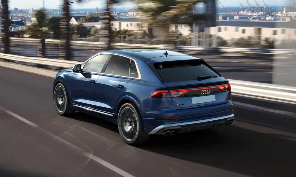 Фото Audi SQ8 (2024) — вид сзади, фото 4. Корма в синем цвете: графика фонарей и пластика пятой двери. Насадки выхлопа или их имитация внизу бампера различают версии Audi SQ8 (2024) — вид сзади, фото 4