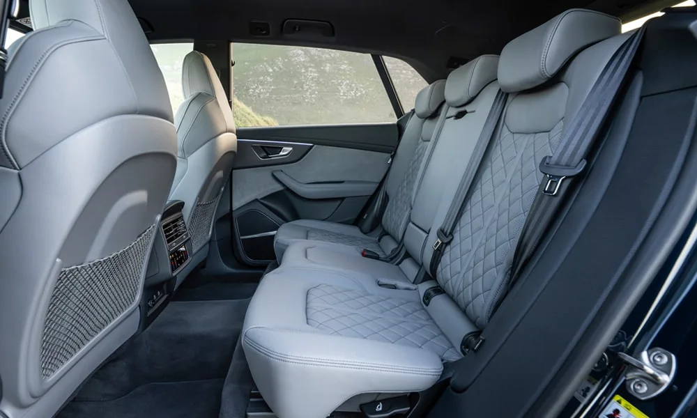Фото Audi SQ8 (2024) — задние сиденья. Посадка второго ряда: подголовники и подлокотник. Крепления ISOFIX для детских кресел — в основании спинки Audi SQ8 (2024) — задние сиденья