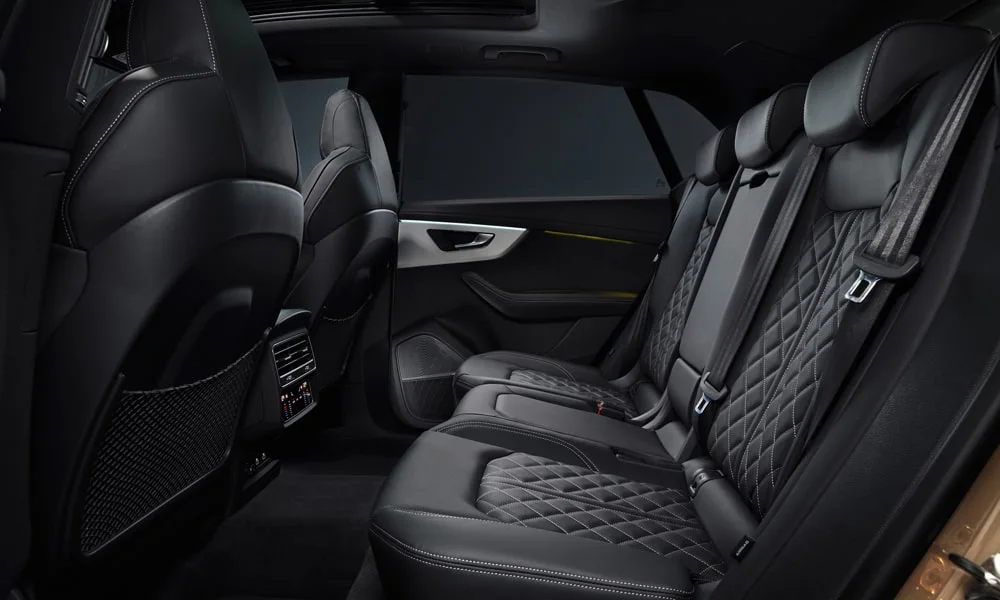 Фото Audi SQ8 (2024) — задние сиденья, фото 2. Посадка второго ряда: подголовники и подлокотник. Спинки складываются под длинные грузы у большинства версий Audi SQ8 (2024) — задние сиденья, фото 2