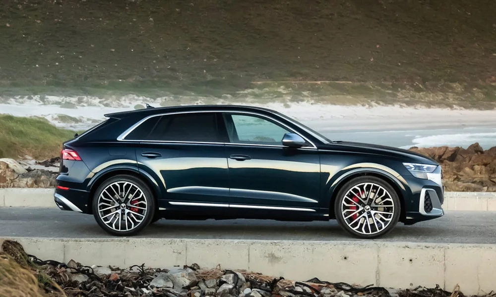 Фото Audi SQ8 (2024) — вид сбоку, фото 2. Чёрный кузов в профиль — пропорции, высота посадки и дизайн дисков. Длинная база — простор второго ряда; короткие свесы упрощают парковку Audi SQ8 (2024) — вид сбоку, фото 2