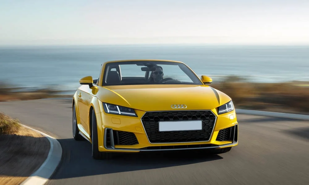 Фото Audi TT — вид спереди, фото 16. Оптика, решётка и бампер — первое впечатление о модели. Рисунок ходовых огней — подпись модели, по нему её узнают в потоке Audi TT — вид спереди, фото 16