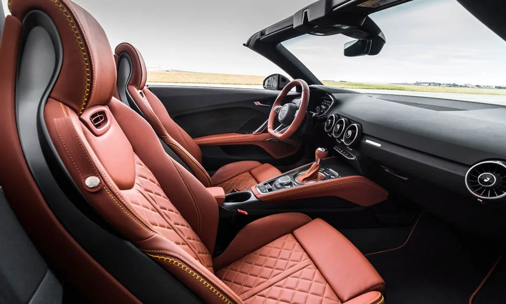 Фото Audi TT — интерьер, фото 7. Общий план салона: посадка, материалы и организация пространства в коричневой гамме. Уровень отделки читается по стыкам панелей и мягким поверхностям в зонах касания Audi TT — интерьер, фото 7