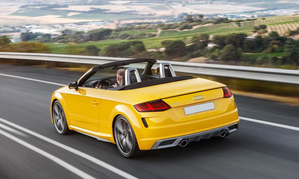Фото Audi TT — вид сзади, фото 14. Корма в жёлтом цвете: графика фонарей и пластика пятой двери. Светодиодная полоса или раздельные секции — задняя оптика стала главным украшением кормы Audi TT — вид сзади, фото 14