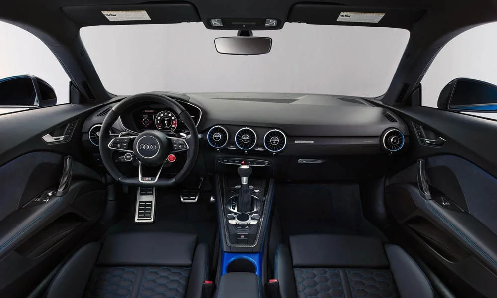 Фото Audi TT RS — передняя панель. Панель в тёмно-синей отделке — видна компоновка экранов и органов управления. Мягкие материалы верхнего яруса и вставки задают уровень интерьера Audi TT RS — передняя панель