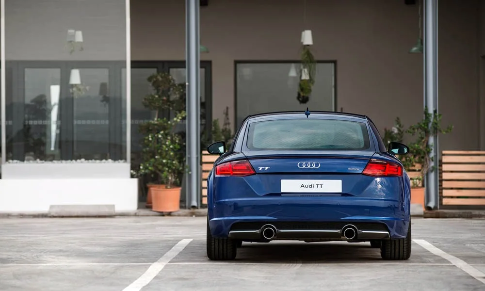 Фото Audi TT — вид сзади, фото 5. Линия крыши, стойки и задняя дверь в синем исполнении. Насадки выхлопа или их имитация внизу бампера различают версии Audi TT — вид сзади, фото 5