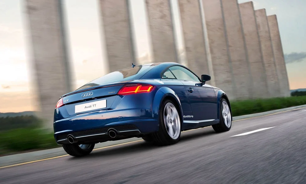 Фото Audi TT — вид сзади, фото 9. Линия крыши, стойки и задняя дверь в синем исполнении. Насадки выхлопа или их имитация внизу бампера различают версии Audi TT — вид сзади, фото 9