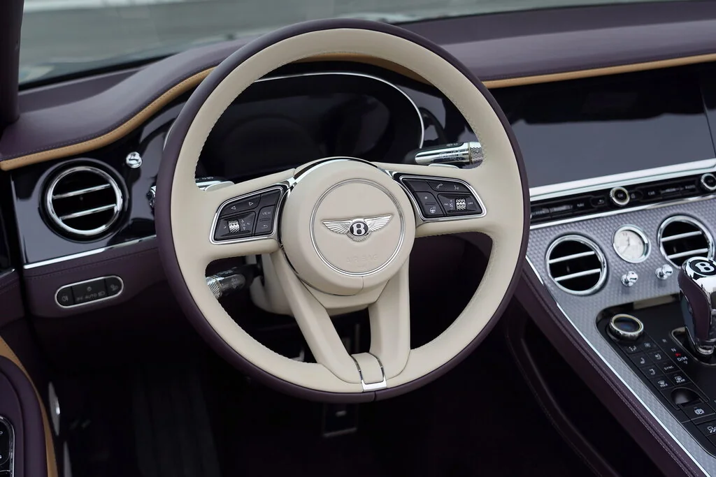 Фото Bentley Continental GT (2024) — руль. Обод, спицы и кнопки на руле крупным планом Bentley Continental GT (2024) — руль