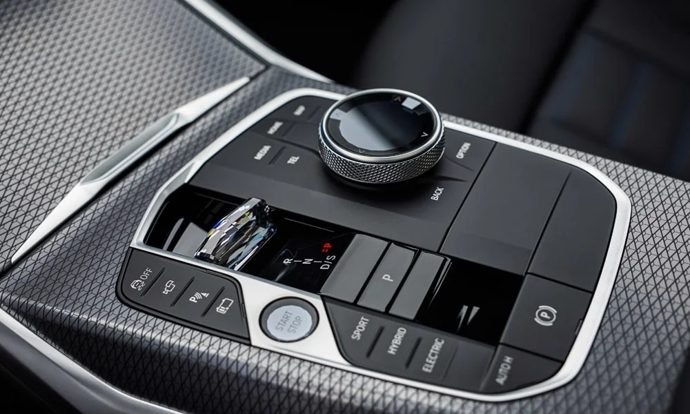 Фото BMW 3 серии Touring (2024) — селектор коробки передач. Селектор трансмиссии на центральной консоли. Автохолд удерживает машину на светофоре без ноги на тормозе BMW 3 серии Touring (2024) — селектор коробки передач