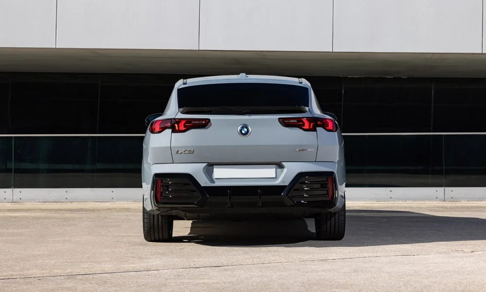 Фото BMW iX2 — вид сзади, фото 5. Серый кузов сзади — фонари и бампер определяют ночной образ модели. Насадки выхлопа или их имитация внизу бампера различают версии BMW iX2 — вид сзади, фото 5