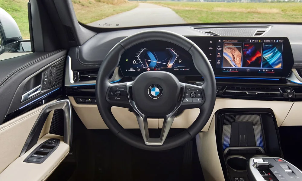 Фото BMW X1 (2024) — интерьер. Общий план салона: архитектура панели, консоль и кресла. Уровень отделки читается по стыкам панелей и мягким поверхностям в зонах касания BMW X1 (2024) — интерьер