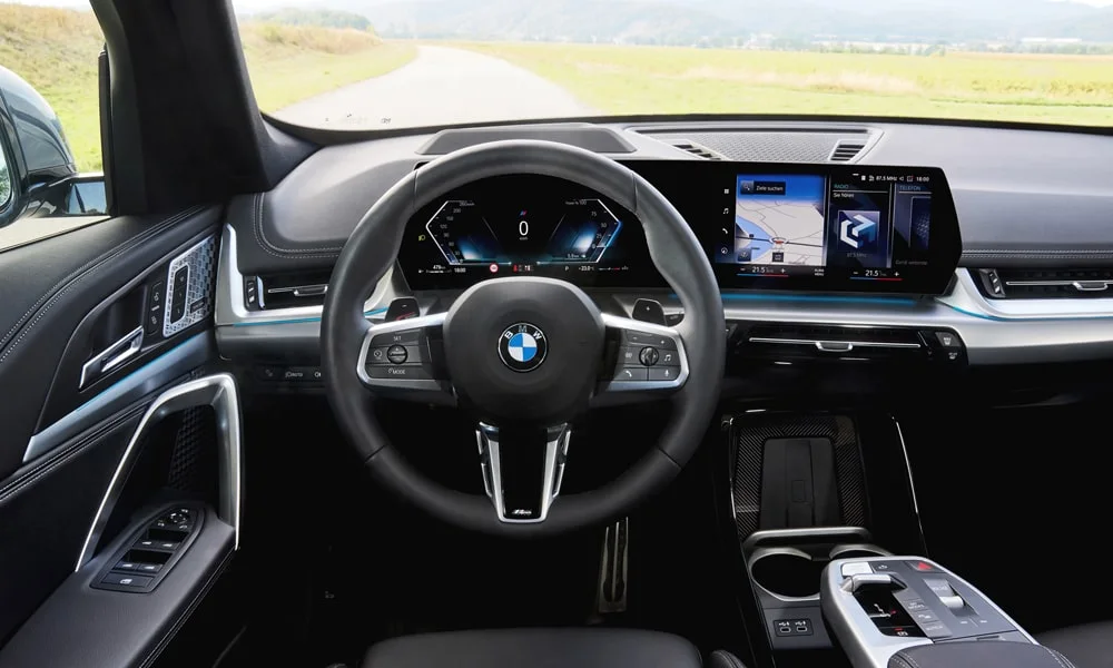 Фото BMW X1 (2024) — руль. Обшивка обода и компоновка спиц крупным планом. Клавиши на спицах управляют медиа, круизом и ассистентами — руки остаются на руле BMW X1 (2024) — руль