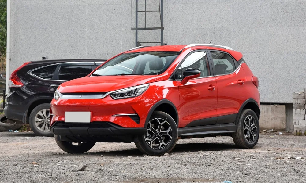 Фото BYD Yuan Pro (2024) — вид сбоку, фото 4. Сбоку читаются линия остекления и характер выштамповок на красном кузове. Хромированные или чёрные молдинги окон отличают комплектации BYD Yuan Pro (2024) — вид сбоку, фото 4
