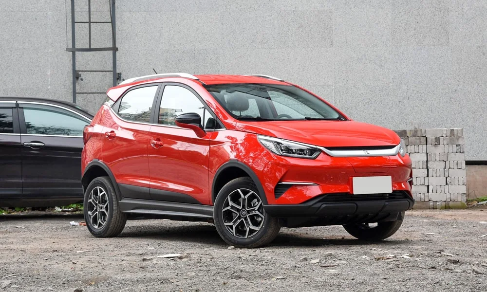 Фото BYD Yuan Pro (2024) — вид сбоку, фото 6. Сбоку читаются линия остекления и характер выштамповок на красном кузове. Хромированные или чёрные молдинги окон отличают комплектации BYD Yuan Pro (2024) — вид сбоку, фото 6