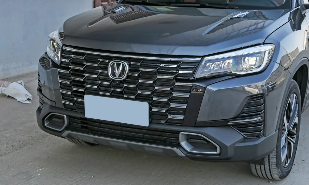 Фото Changan CS75 (2024) — решётка радиатора. Фирменный рисунок облицовки — визитная карточка марки. Активные жалюзи за решёткой закрываются на трассе ради аэродинамики — есть у ряда моделей Changan CS75 (2024) — решётка радиатора