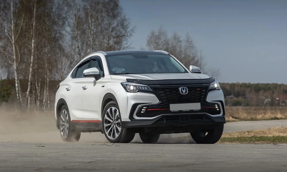 Фото Changan CS85 Coupe (2023) — вид спереди, фото 4. Белый кузов, строгая симметрия оптики — базовый ракурс знакомства с дизайном. Рисунок ходовых огней — подпись модели, по нему её узнают в потоке Changan CS85 Coupe (2023) — вид спереди, фото 4
