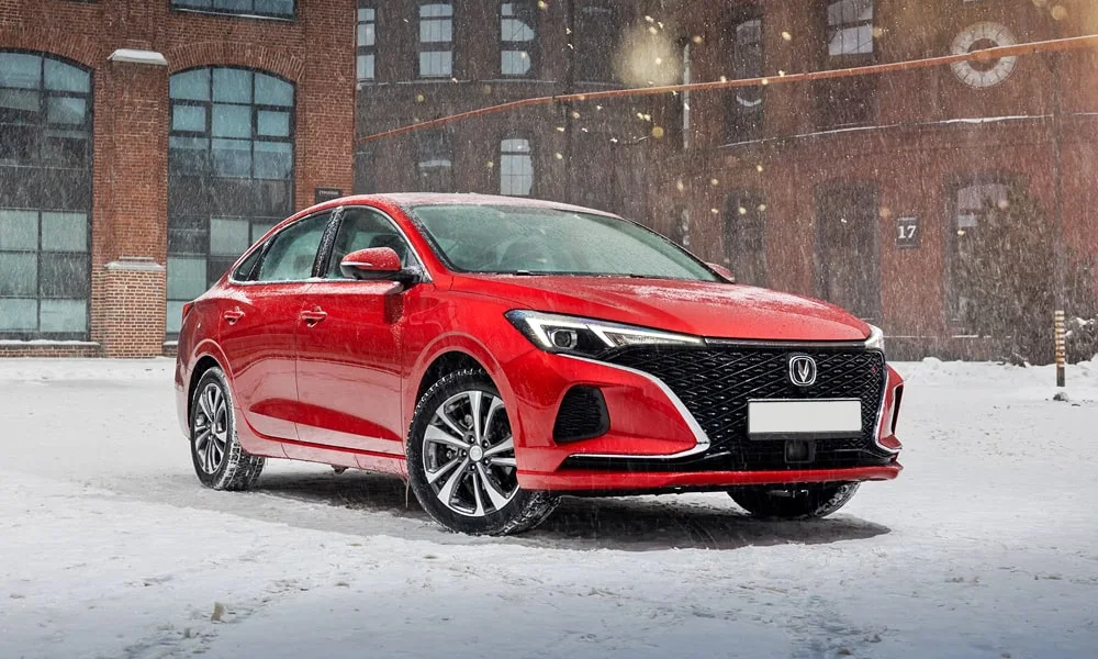 Фото Changan Eado Plus (2023) — вид спереди, фото 7. Красный кузов, строгая симметрия оптики — базовый ракурс знакомства с дизайном. Рисунок ходовых огней — подпись модели, по нему её узнают в потоке Changan Eado Plus (2023) — вид спереди, фото 7