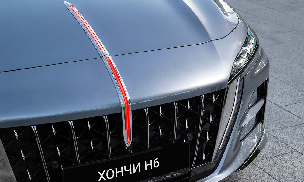 Фото Hongqi H6 (2024) — вид спереди, фото 6. Передок в сером исполнении — крупная светотехника и выразительный бампер. Рисунок ходовых огней — подпись модели, по нему её узнают в потоке Hongqi H6 (2024) — вид спереди, фото 6