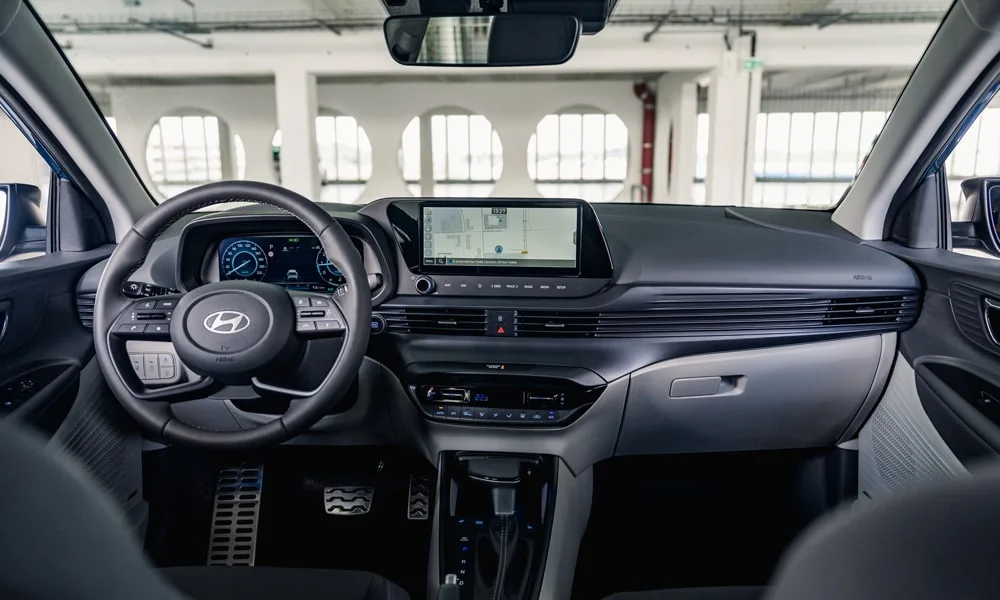 Фото Hyundai Bayon (2024) — передняя панель. Передняя панель в тёмно-синей отделке: расположение экранов и дефлекторов. Мягкие материалы верхнего яруса и вставки задают уровень интерьера Hyundai Bayon (2024) — передняя панель