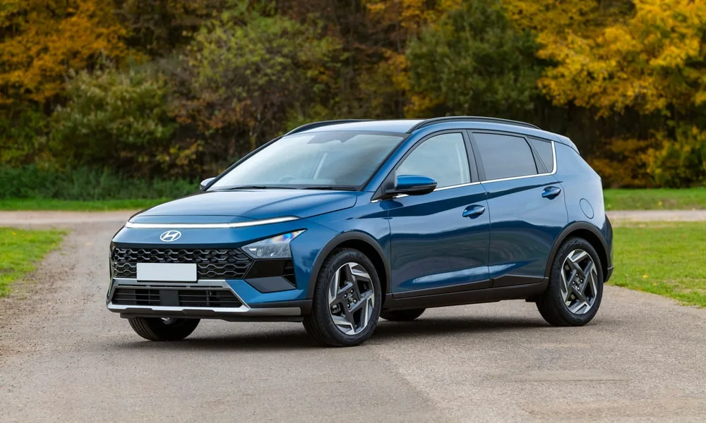 Фото Hyundai Bayon (2024) — вид спереди, фото 8. Кузов в синем цвете: рисунок оптики и решётки задаёт узнаваемое «лицо» модели. Рисунок ходовых огней — подпись модели, по нему её узнают в потоке Hyundai Bayon (2024) — вид спереди, фото 8