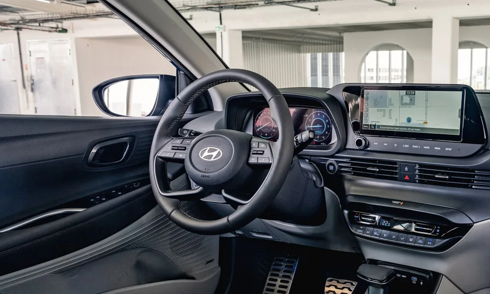 Фото Hyundai Bayon (2024) — интерьер. Общий план салона: архитектура панели, консоль и кресла. Светлая гамма зрительно расширяет салон, тёмная — практичнее в уходе Hyundai Bayon (2024) — интерьер