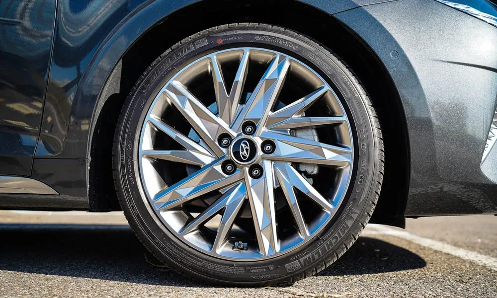 Фото Hyundai Grandeur — колесо и диск. Дизайн спиц и профиль резины крупным планом. Рекомендованные размеры шин и давление — на табличке в проёме водительской двери Hyundai Grandeur — колесо и диск