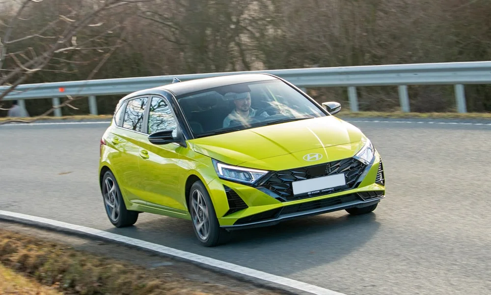 Фото Hyundai i20 — вид спереди, фото 4. Кузов в зелёном цвете: рисунок оптики и решётки задаёт узнаваемое «лицо» модели. Дневные ходовые огни включаются автоматически с запуском Hyundai i20 — вид спереди, фото 4