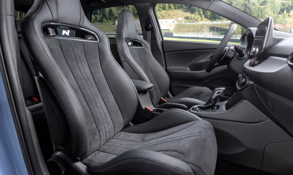 Фото Hyundai i30 Fastback N (2024) — передние сиденья. Передние кресла в алькантаре. Выраженная боковая поддержка держит в поворотах Hyundai i30 Fastback N (2024) — передние сиденья