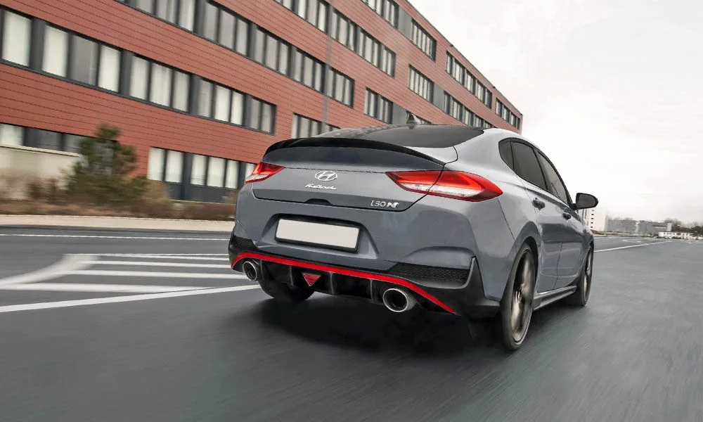 Фото Hyundai i30 Fastback N (2024) — вид сзади, фото 4. Корма в сером цвете: графика фонарей и пластика пятой двери. Светодиодная полоса или раздельные секции — задняя оптика стала главным украшением кормы Hyundai i30 Fastback N (2024) — вид сзади, фото 4