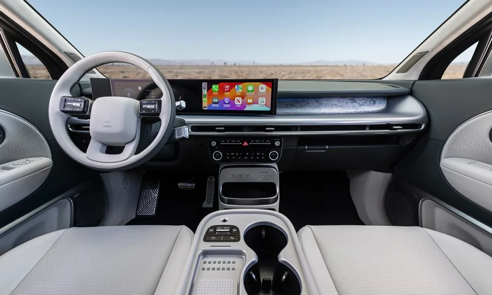 Фото Hyundai IONIQ 9 (2024) — передняя панель. Архитектура передней панели: ярусы, вставки и консоль в светло-серой гамме. Мягкие материалы верхнего яруса и вставки задают уровень интерьера Hyundai IONIQ 9 (2024) — передняя панель