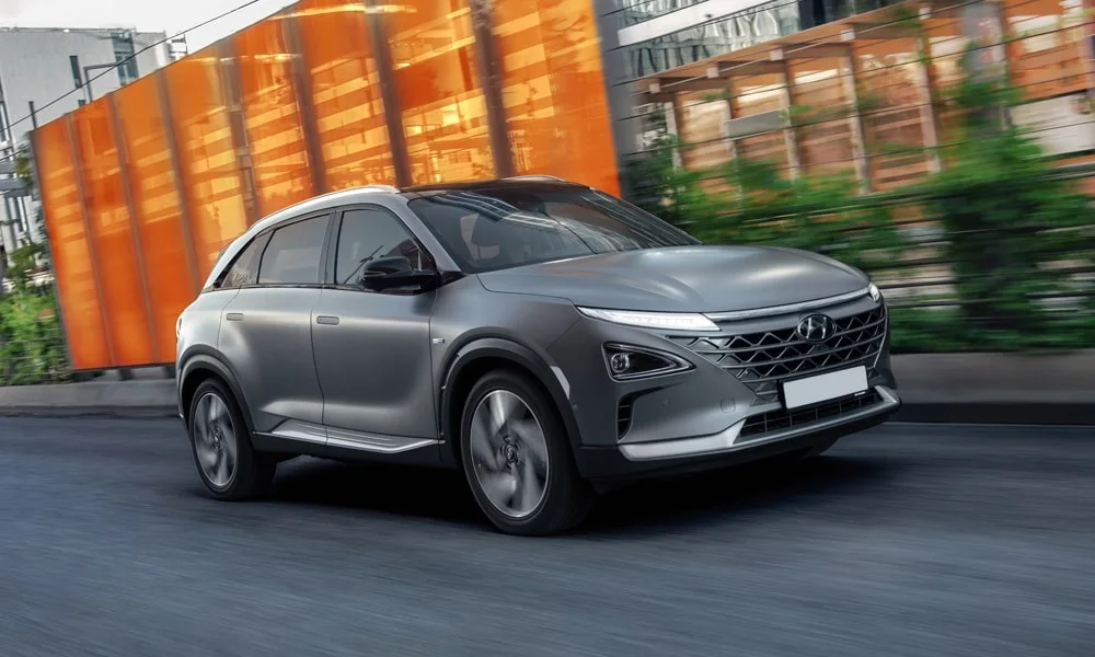Фото Hyundai NEXO (2024) — вид спереди, фото 4. Кузов в серебристом цвете: рисунок оптики и решётки задаёт узнаваемое «лицо» модели. Рисунок ходовых огней — подпись модели, по нему её узнают в потоке Hyundai NEXO (2024) — вид спереди, фото 4