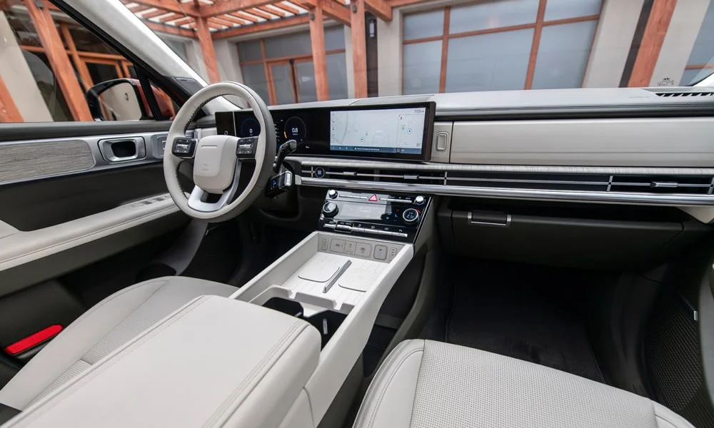 Фото Hyundai Santa Fe (2024) — передняя панель. Панель в светло-серой отделке — видна компоновка экранов и органов управления. Минимум физических кнопок — ставка на экранное управление Hyundai Santa Fe (2024) — передняя панель