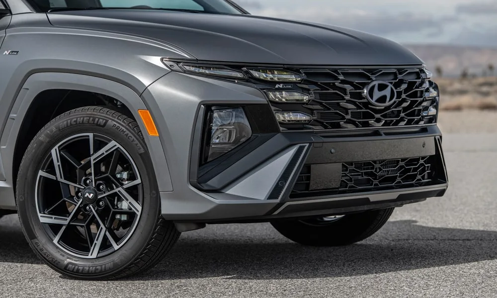 Фото Hyundai Tucson N Line (2024) — вид спереди, фото 6. Кузов в сером цвете: рисунок оптики и решётки задаёт узнаваемое «лицо» модели Hyundai Tucson N Line (2024) — вид спереди, фото 6