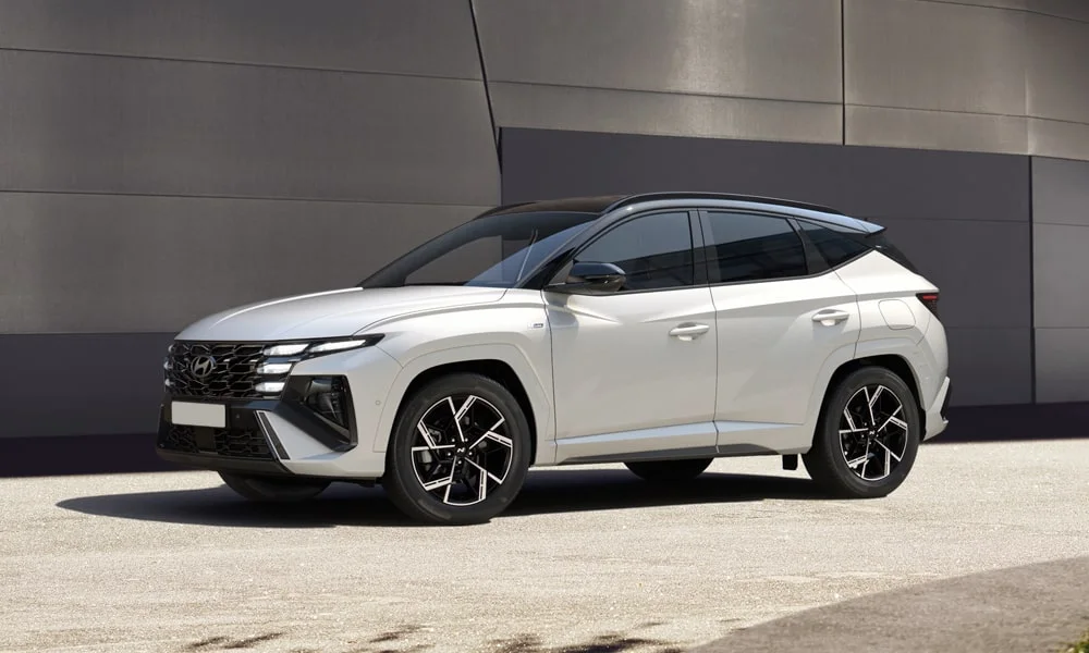 Фото Hyundai Tucson N Line (2024) — вид спереди, фото 11. Кузов в белом цвете: рисунок оптики и решётки задаёт узнаваемое «лицо» модели Hyundai Tucson N Line (2024) — вид спереди, фото 11