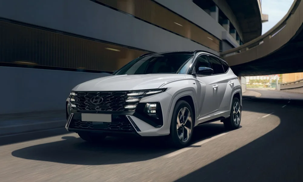 Фото Hyundai Tucson N Line (2024) — вид спереди, фото 12. Передок в белом исполнении — крупная светотехника и выразительный бампер Hyundai Tucson N Line (2024) — вид спереди, фото 12
