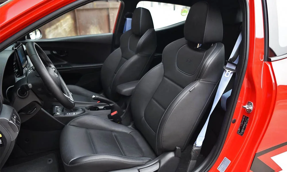 Фото Hyundai Veloster N (2024) — передние сиденья. Водительское и пассажирское кресла: обивка из перфорированной коже, профиль с боковой поддержкой Hyundai Veloster N (2024) — передние сиденья