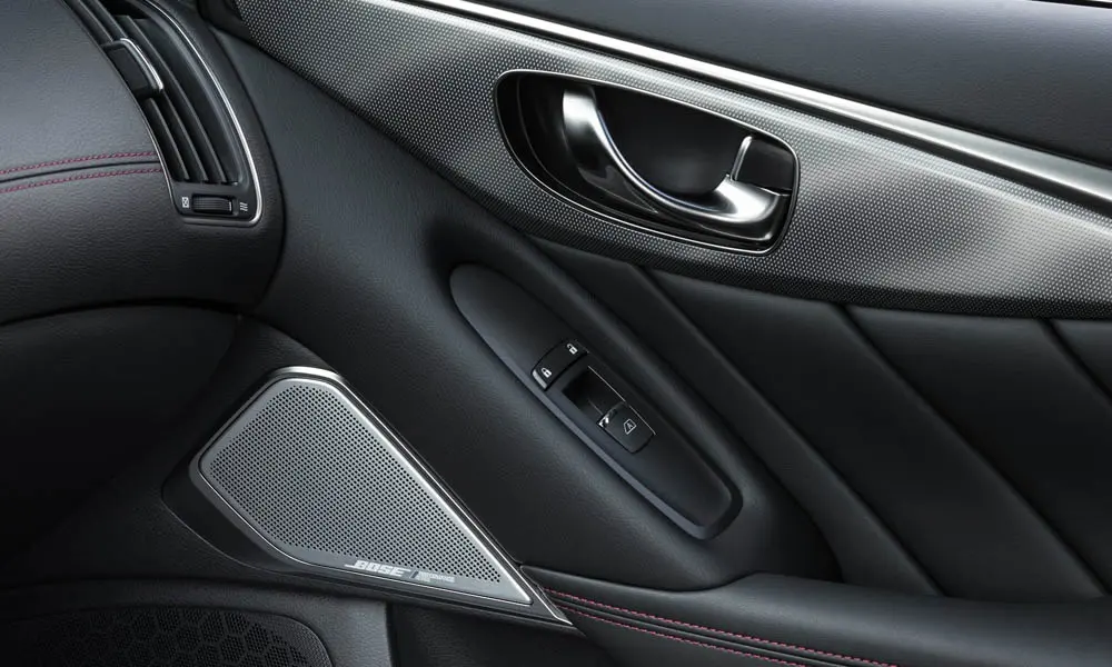 Фото Infiniti Q50 — дверная карта. Дверная карта в тёмной отделке: подлокотник, динамик и блок стеклоподъёмников. Мягкая вставка в зоне локтя — то, что чувствуешь каждый день Infiniti Q50 — дверная карта