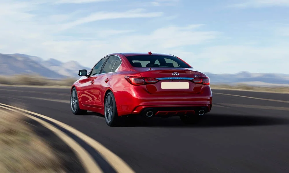 Фото Infiniti Q50 — вид сзади, фото 3. Красный кузов сзади — фонари и бампер определяют ночной образ модели Infiniti Q50 — вид сзади, фото 3